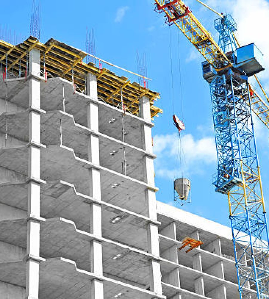 Crane and building under construction against blue sky
